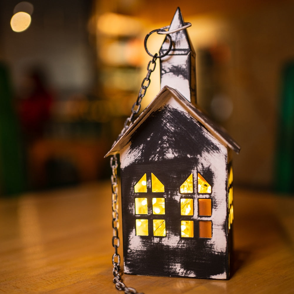 Yellow Marigold black metal hanging birdhouse lantern — black metal lantern shaped like a birdhouse, hanging against plain background