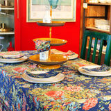 Yellow Marigold Eternal Rose Navy napkins (set of 6) placed beside crockery on a wooden dining table with flowers — elegant table setting for dinner