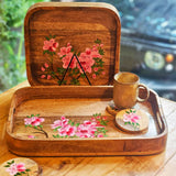 Lifestyle view: Yellow Marigold hand-painted Pink Azalea coasters on a wooden table – eco-friendly, artisan-crafted drinkware accessory.